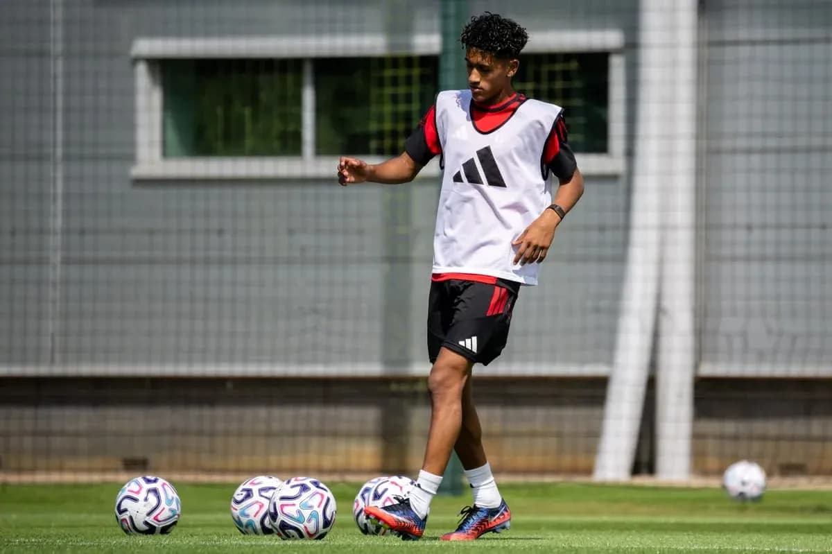 Jugador entrenando con balones en campo de fútbol