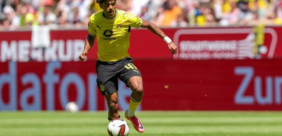 Jugador de Borussia Dortmund corriendo con balón en el campo