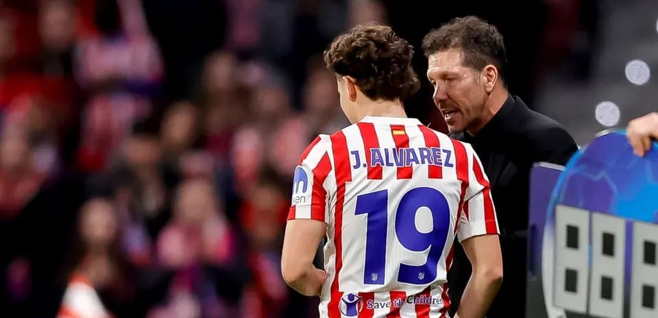Entrenador hablando con jugador J. Álvarez en el campo