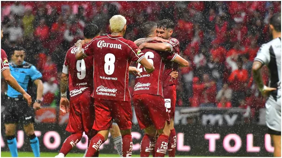Jugadores de Toluca celebrando un gol en lluvia