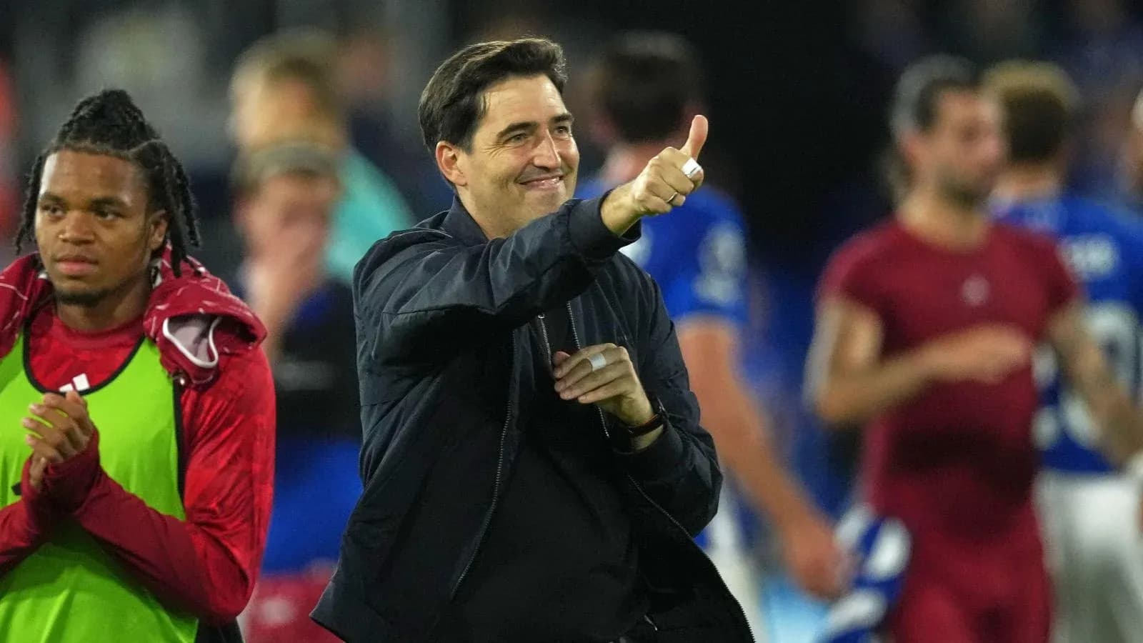 Entrenador sonriendo y levantando el pulgar tras el partido