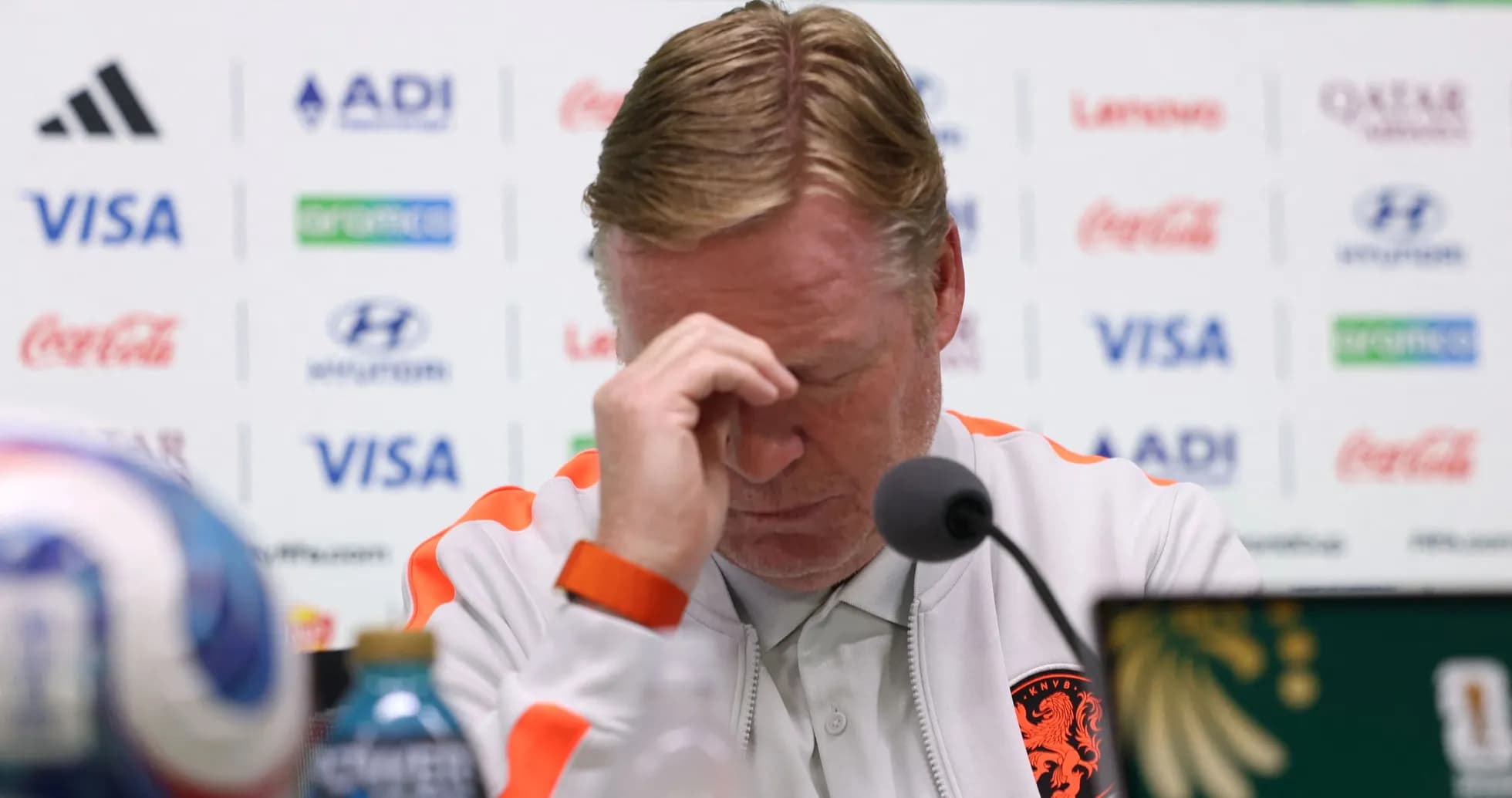 Entrenador en conferencia de prensa con expresión preocupada
