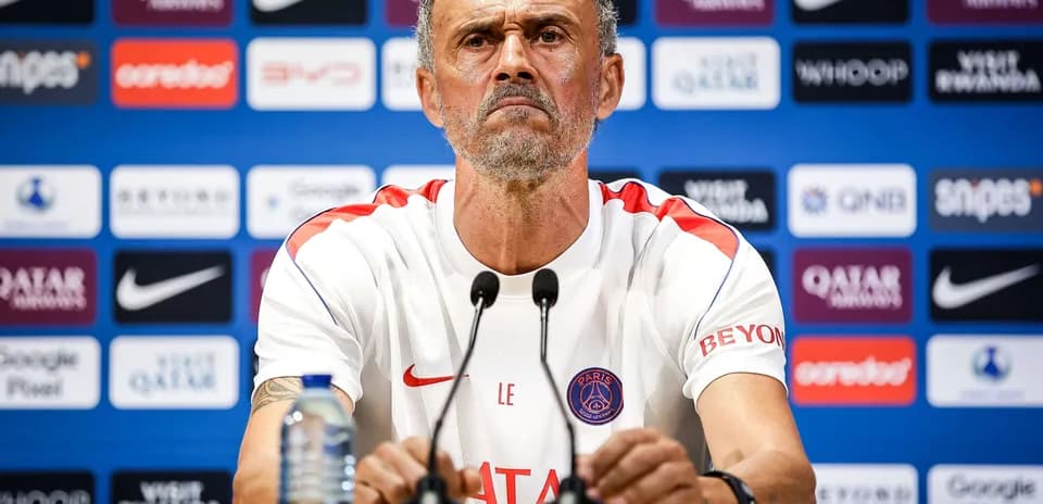 Entrenador en conferencia de prensa con logotipos de patrocinadores