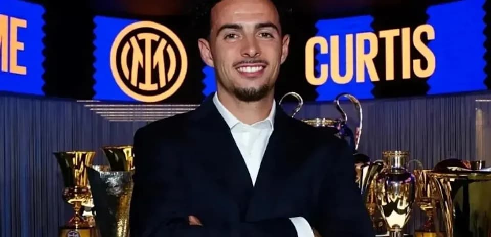 Jugador posando frente a trofeos en evento