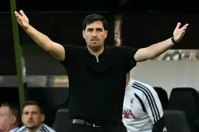 Entrenador gesticulando durante un partido de fútbol