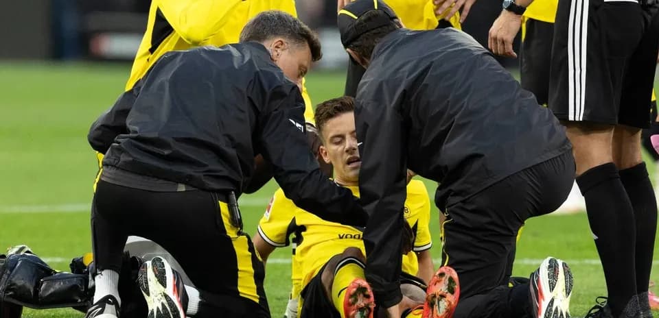 Jugadores y personal médico atendiendo a un jugador caído