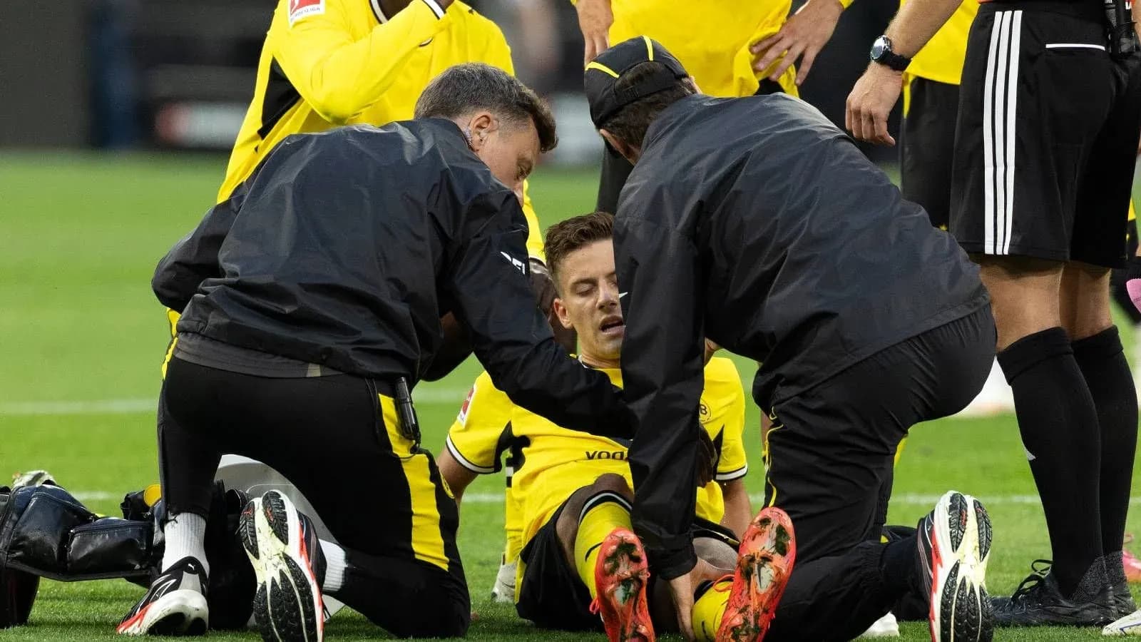 Jugadores y personal médico atendiendo a un jugador caído