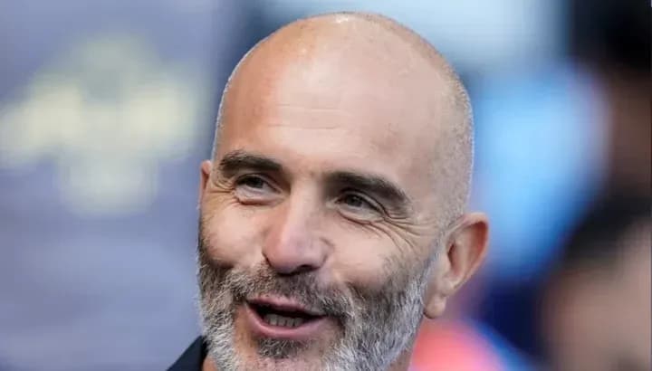 Entrenador sonriendo durante el partido