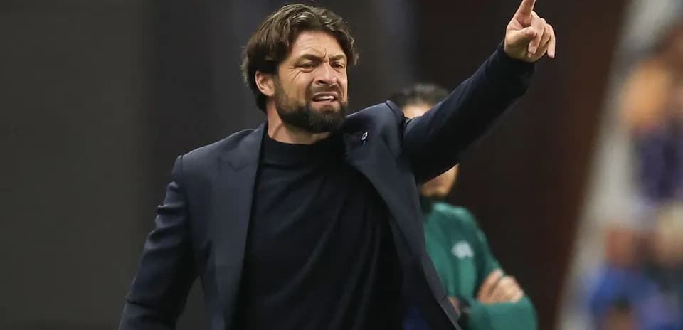 Entrenador dirigiendo a su equipo desde la banda