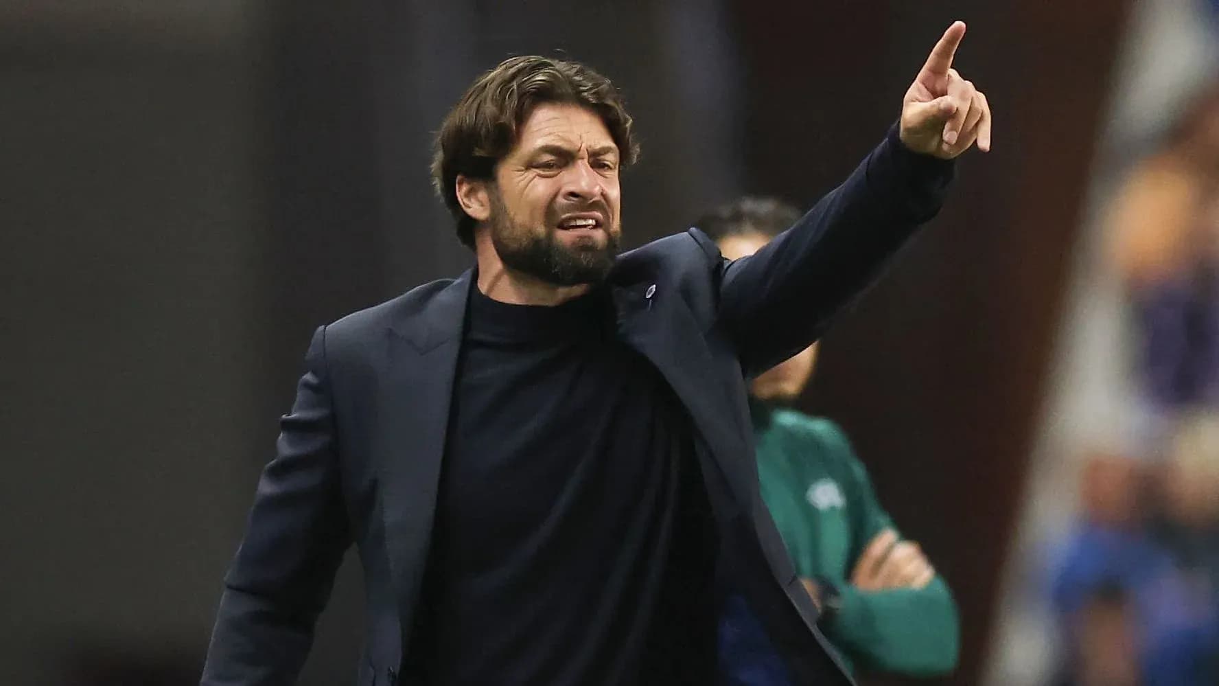 Entrenador dirigiendo a su equipo desde la banda