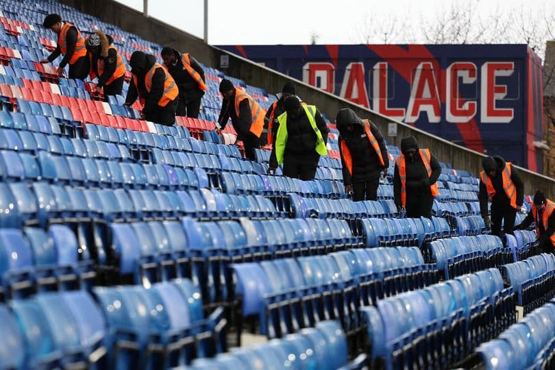 Personal limpiando las gradas en estadio de fútbol