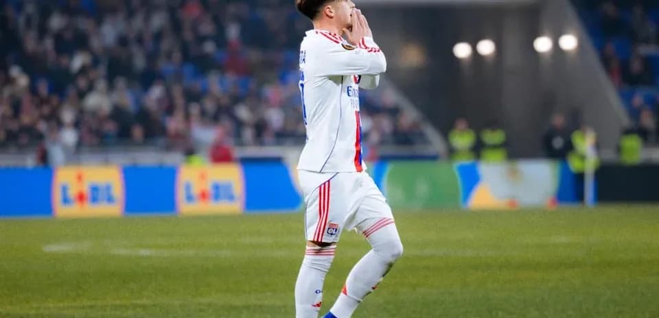 Jugador de Lyon señalando hacia la grada durante partido