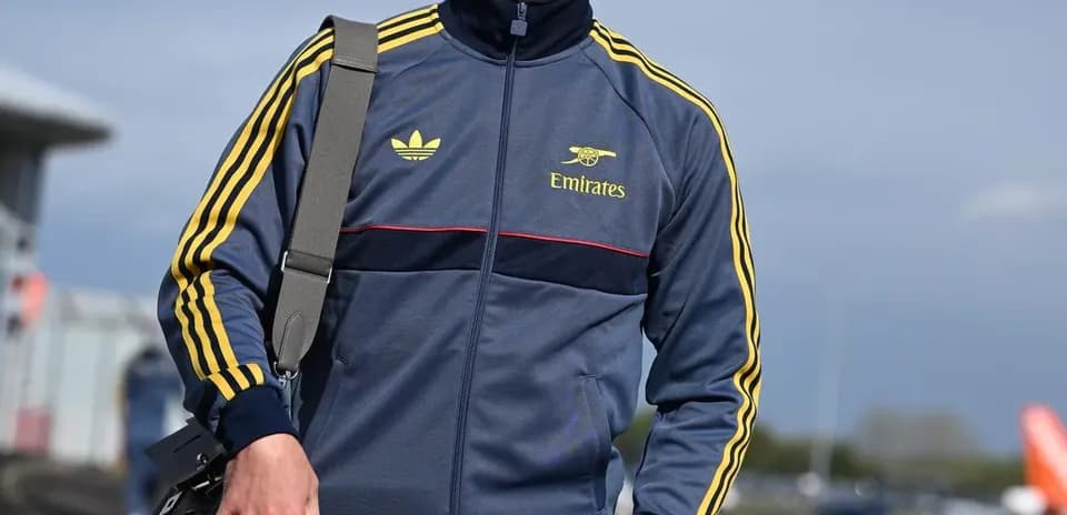 Jugador vestido con chándal caminando en el aeropuerto