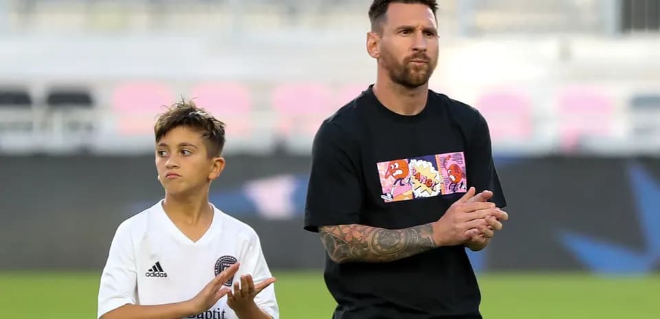 Lionel Messi y un niño aplaudiendo juntos