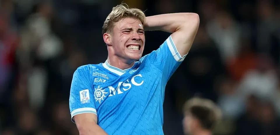 Jugador de fútbol sosteniéndose la cabeza en el campo