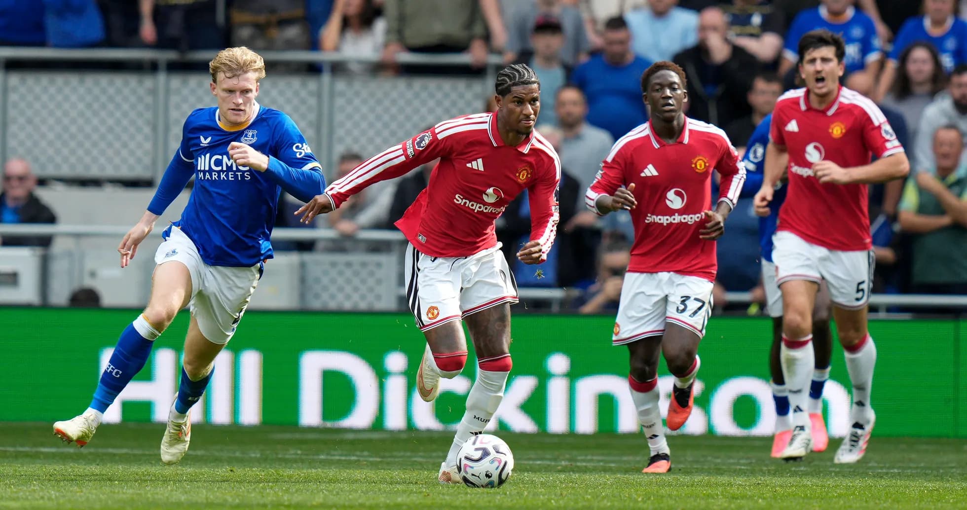 Jugadores de Manchester United corriendo tras el balón