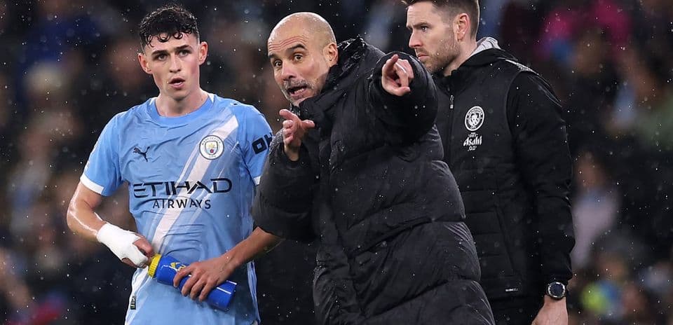 Pep Guardiola dando instrucciones a un jugador de Manchester City