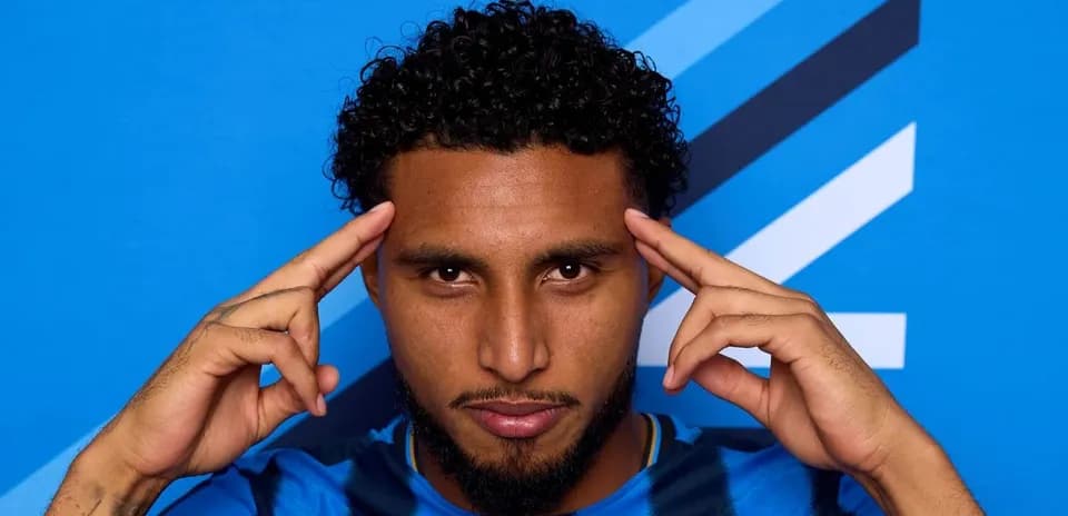 Jugador posando con fondo azul y camiseta a rayas