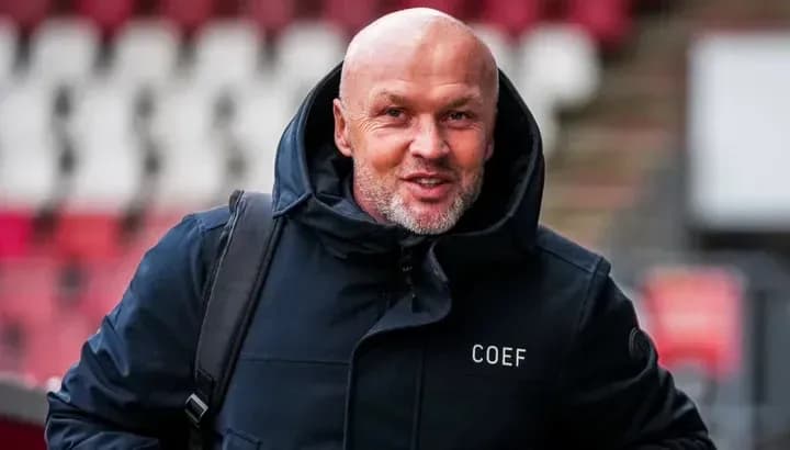 Hombre sonriendo con chaqueta en estadio