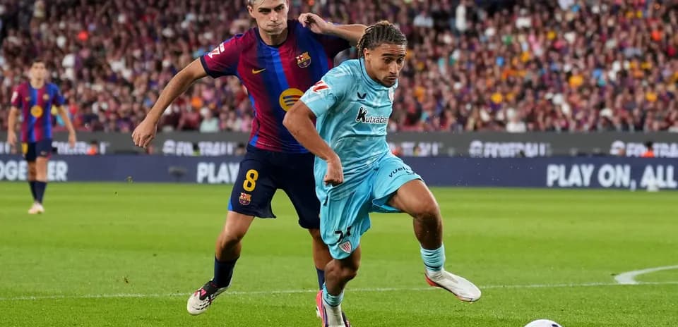 Jugador del Barcelona persiguiendo a oponente en partido