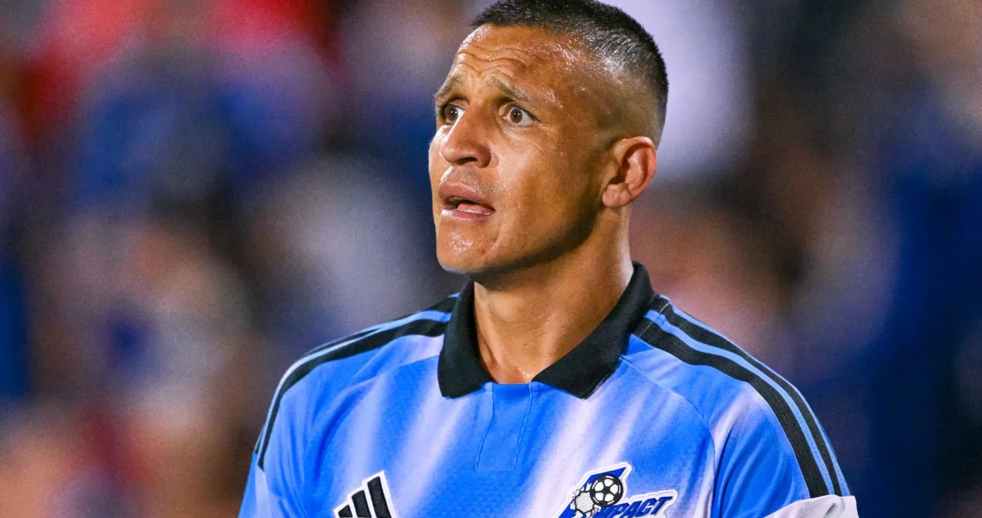 Jugador de fútbol en uniforme azul mirando hacia arriba