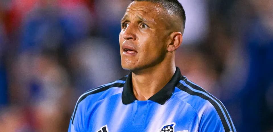 Jugador de fútbol en uniforme azul mirando hacia arriba