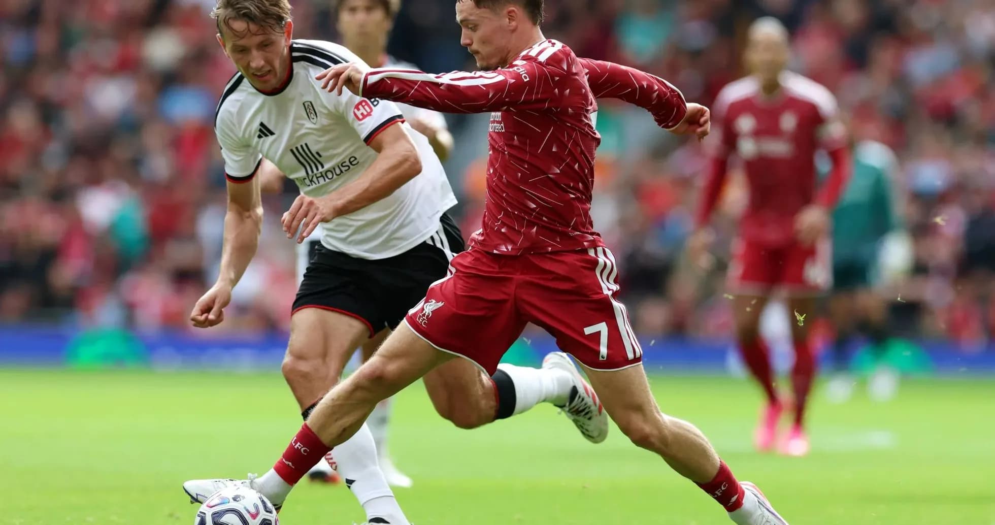 Jugador de Liverpool desafiando a rival de Fulham