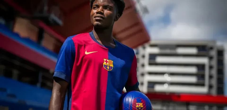 Jugador sosteniendo un balón en el estadio del Barcelona
