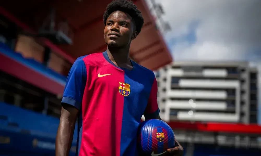 Jugador sosteniendo un balón en el estadio del Barcelona