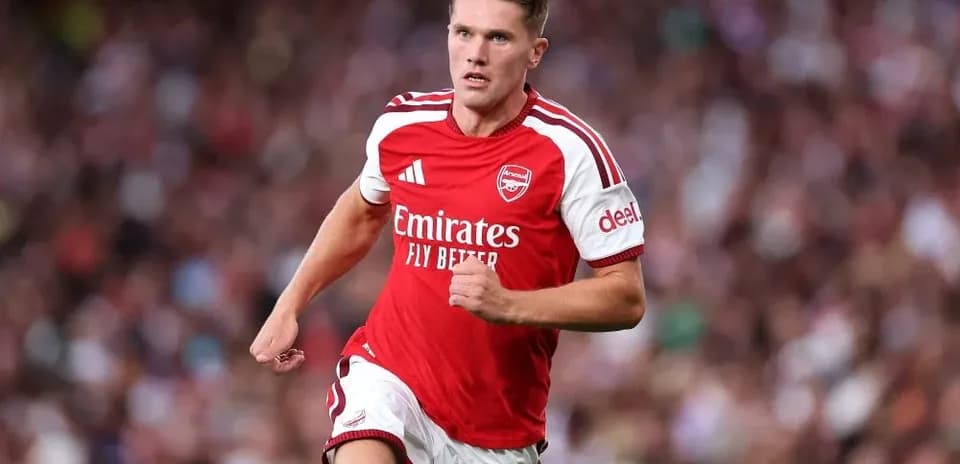 Jugador de Arsenal corriendo en el campo de fútbol