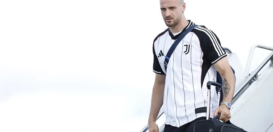 Jugador de Juventus desembarcando del avión con maleta