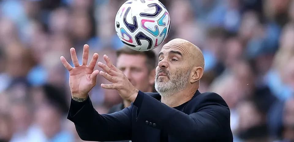 Entrenador intentando atrapar un balón en el partido