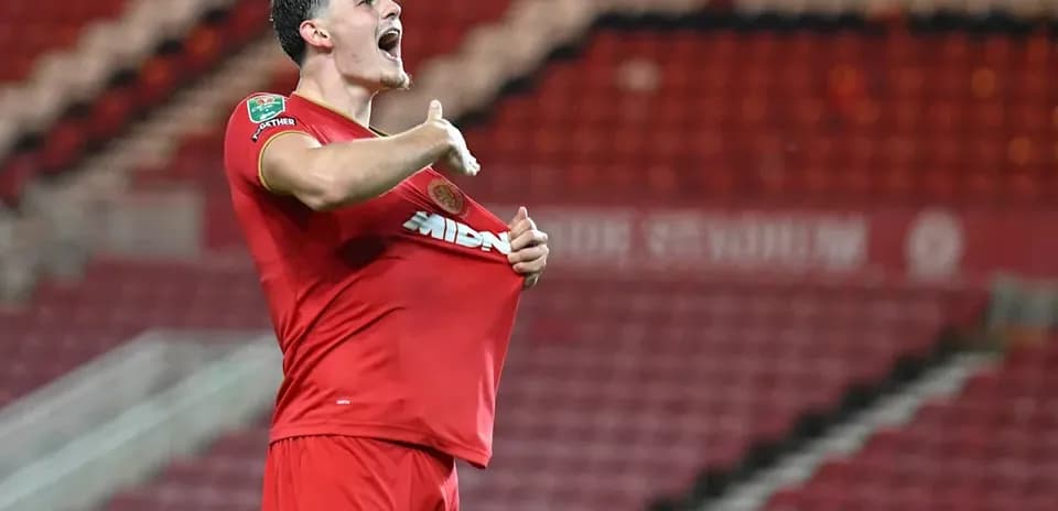 Jugador celebrando y mostrando su camiseta durante el partido