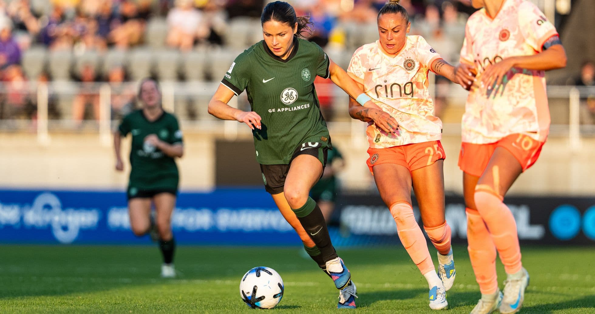 Una jugadora corriendo con el balón en el partido