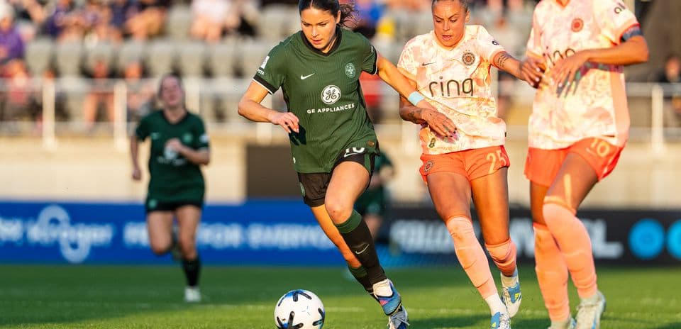Una jugadora corriendo con el balón en el partido