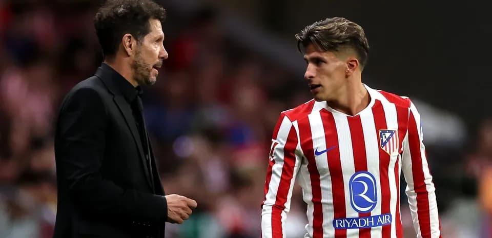 Entrenador y jugador de Atlético de Madrid conversando