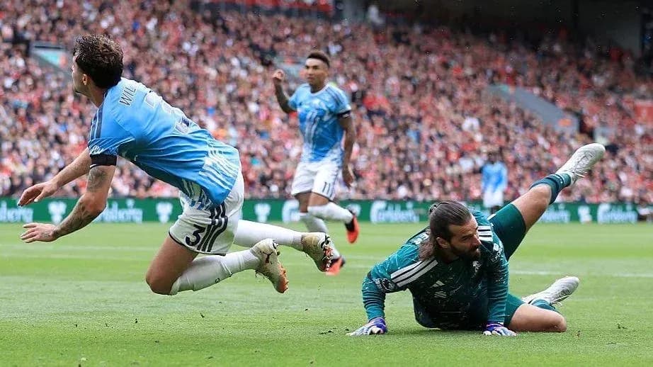 Jugador caído mientras el portero detiene el balón