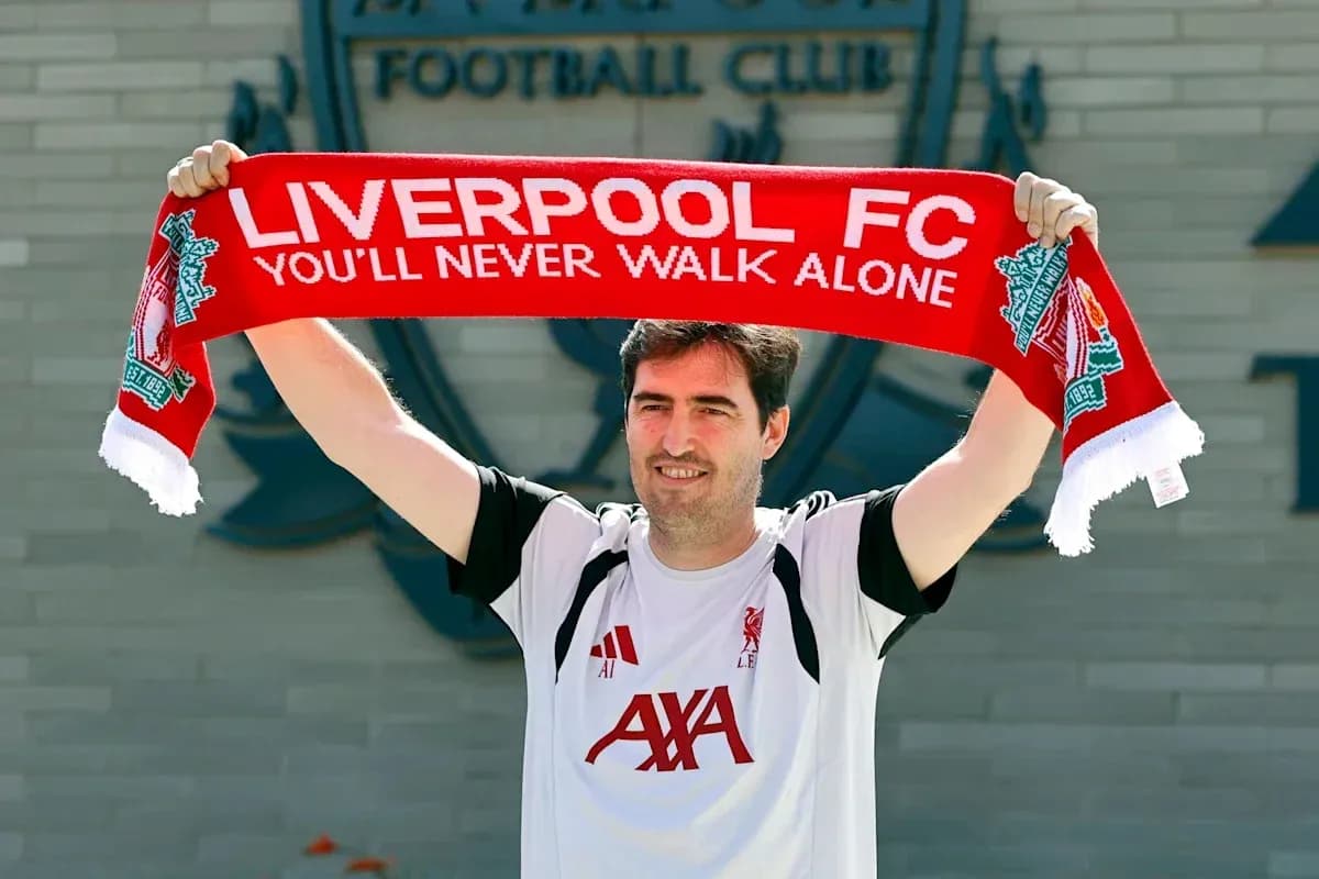 Jugador sosteniendo una bufanda de Liverpool FC