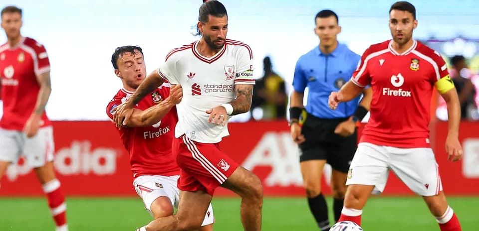 Jugador de Liverpool esquivando a oponente en partido