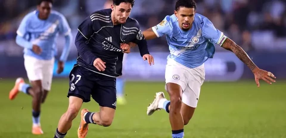 Jugador de Real Madrid corriendo con balón, seguido por rival