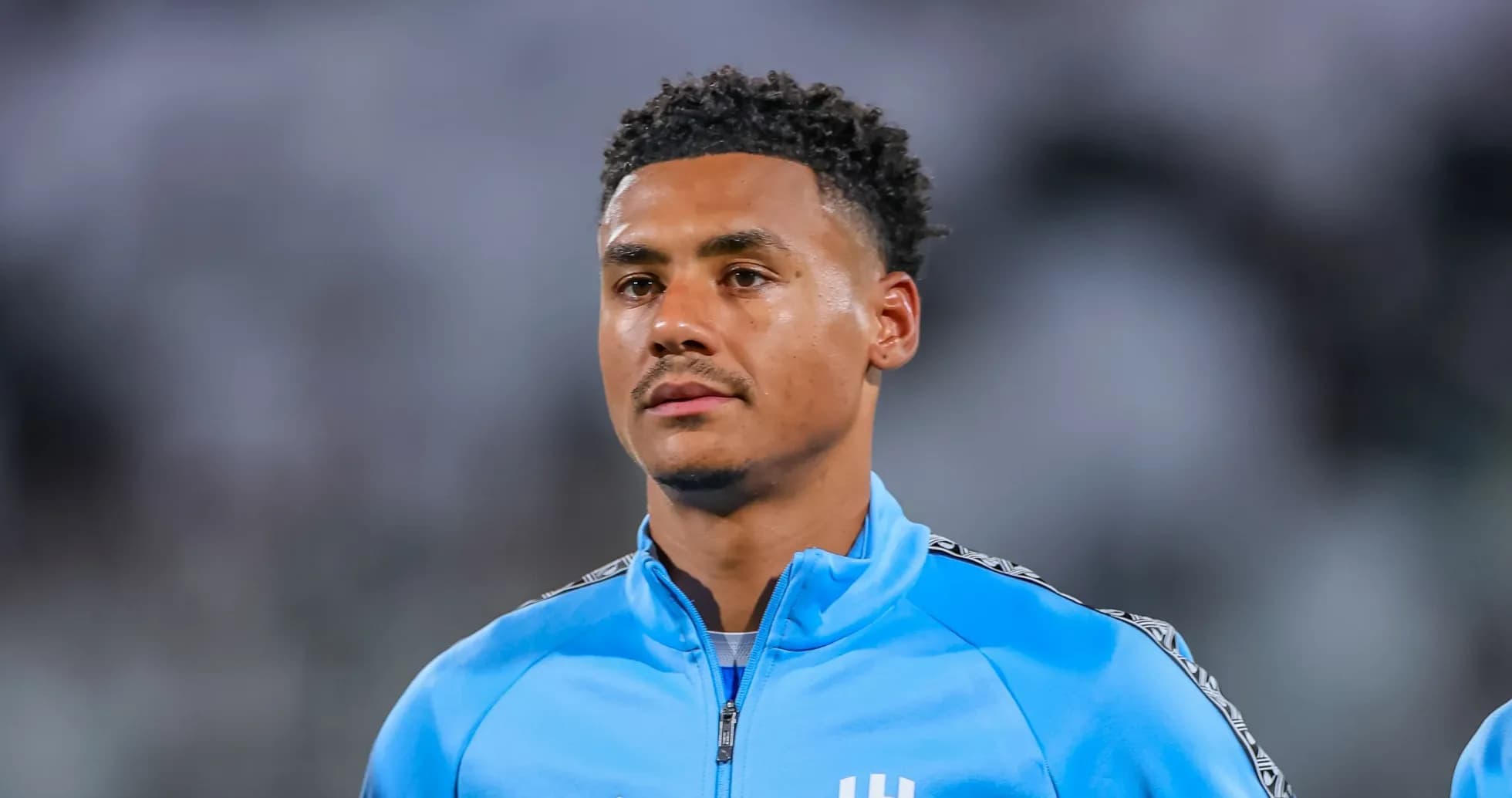Jugador con chaqueta azul en el campo de fútbol
