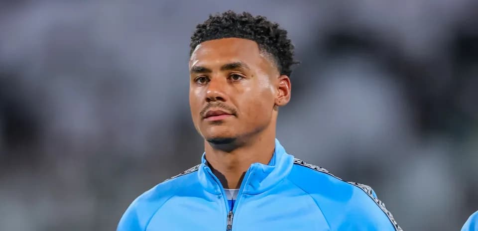 Jugador con chaqueta azul en el campo de fútbol