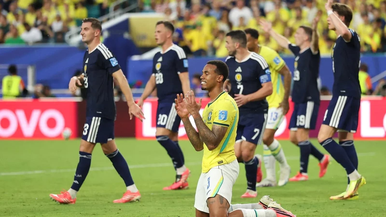 Jugadores de Brasil y Escocia en partido de fútbol