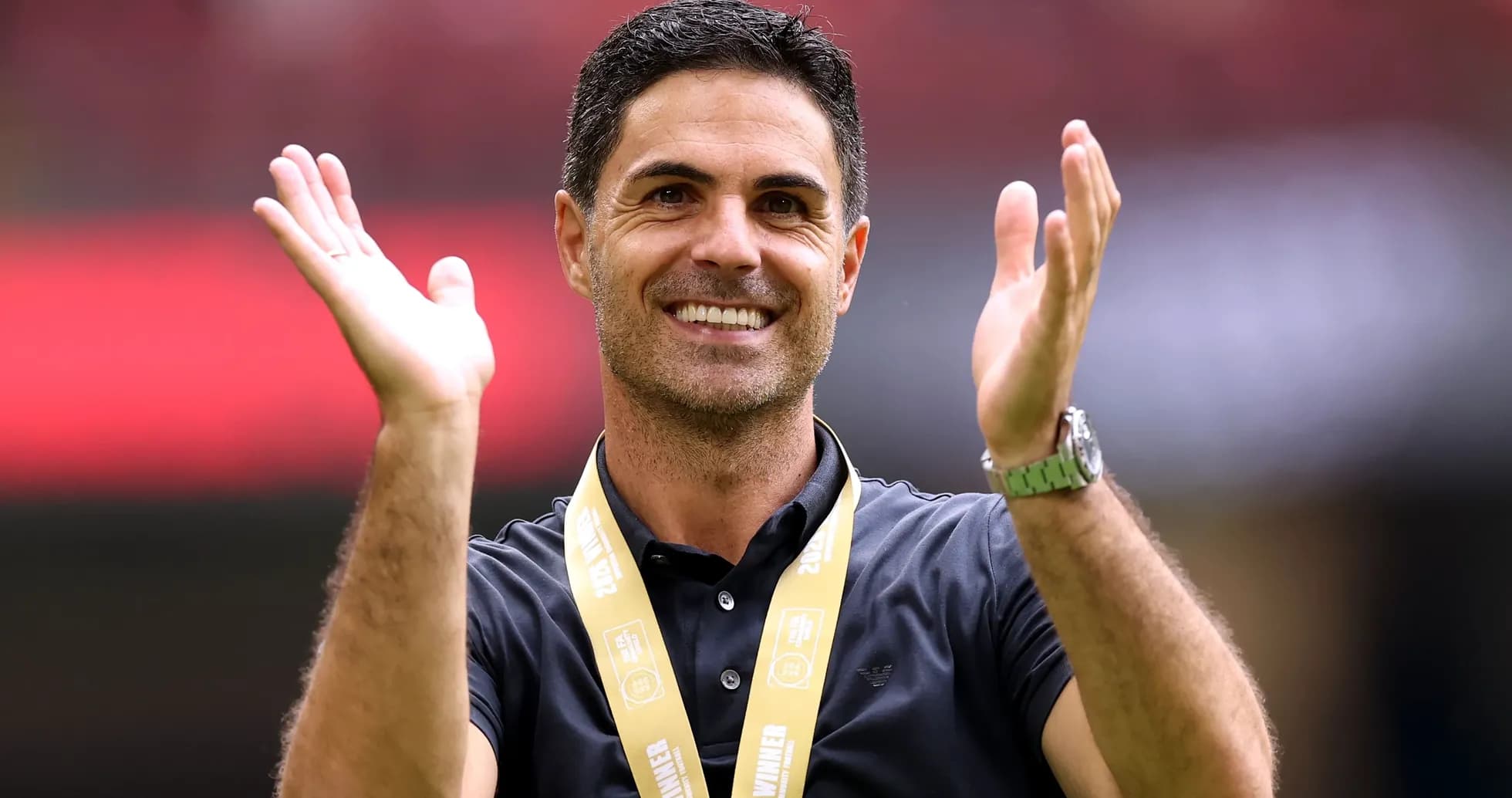 Entrenador aplaudiendo con medalla en el cuello