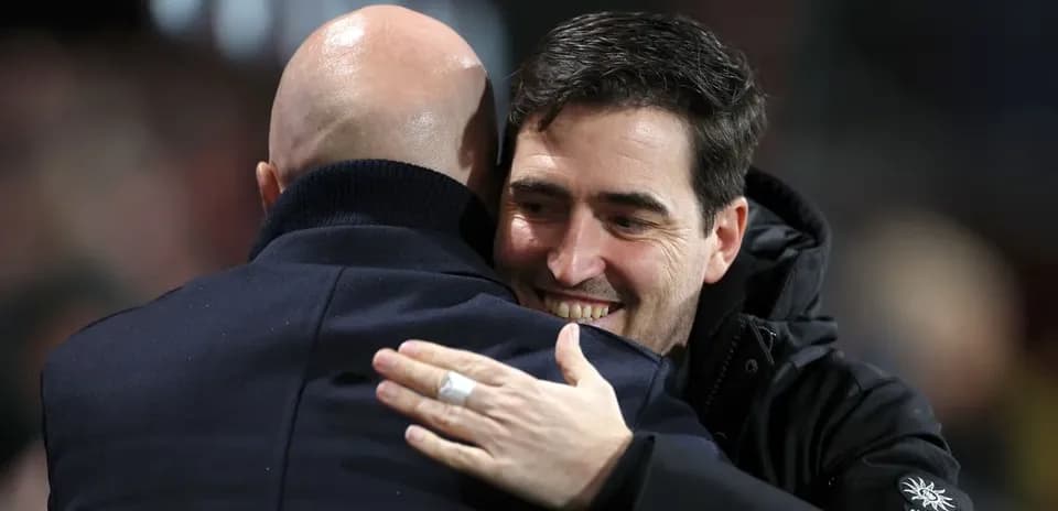 Dos entrenadores abrazándose durante un partido