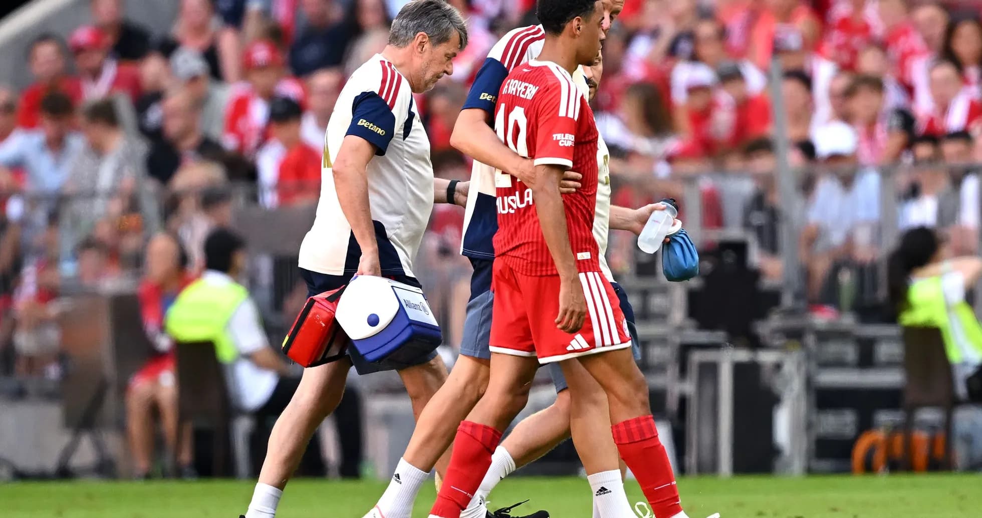 Jugador siendo ayudado por el personal médico en el campo