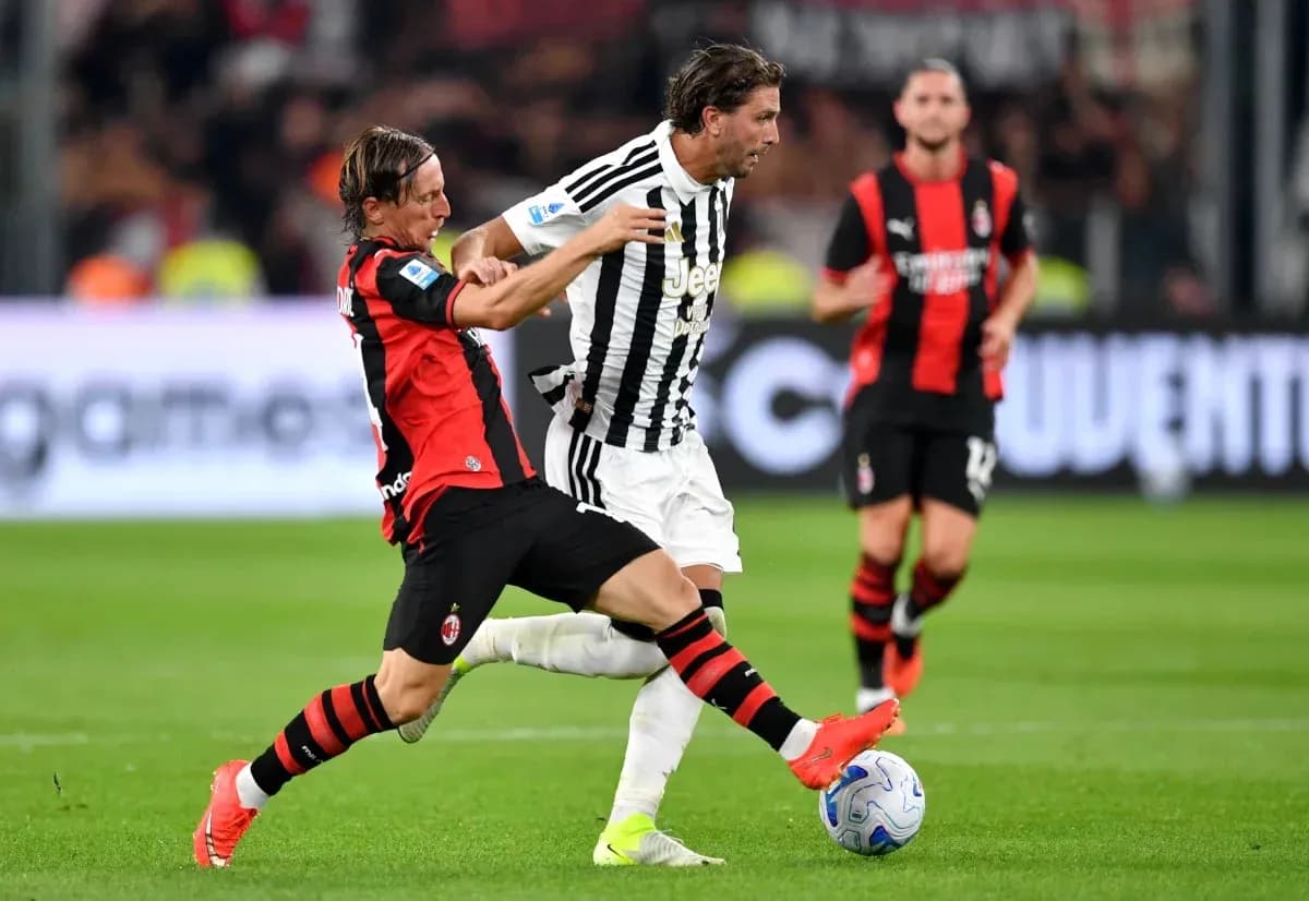 Jugador de AC Milan intenta quitar el balón a jugador de Juventus