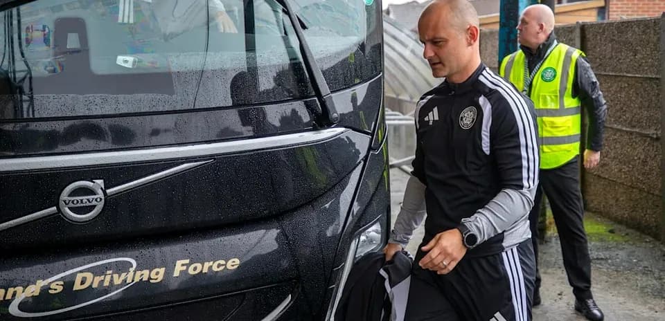 Entrenador llegando al autobús del equipo bajo la lluvia