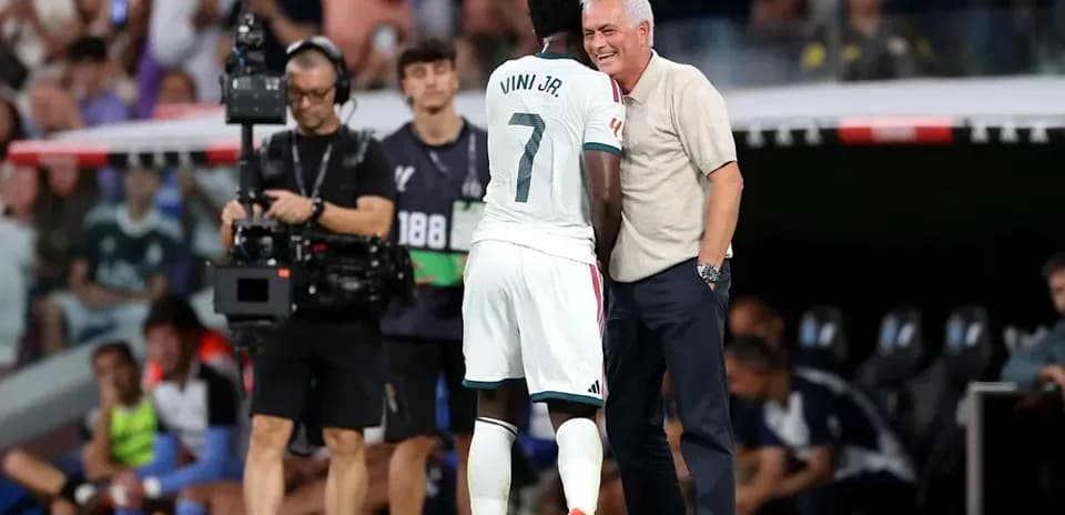 Vini Jr. conversando con el entrenador en el campo
