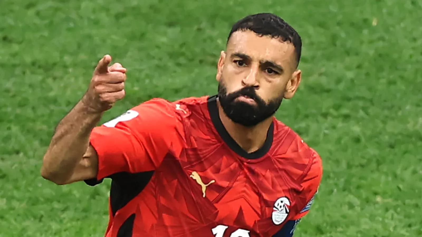 Jugador egipcio señalando durante un partido de fútbol